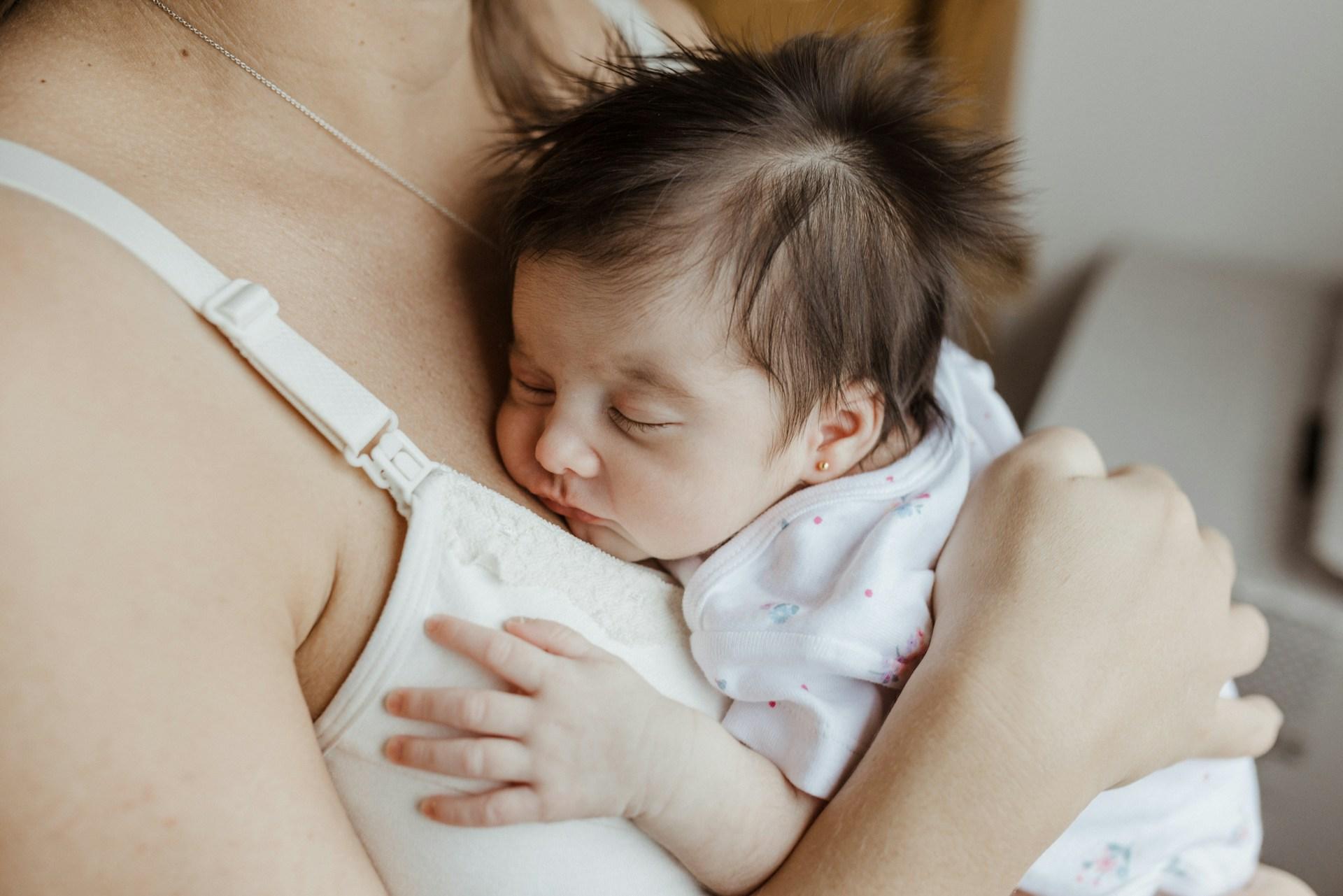 Parent feeding newborn in a cozy nursery