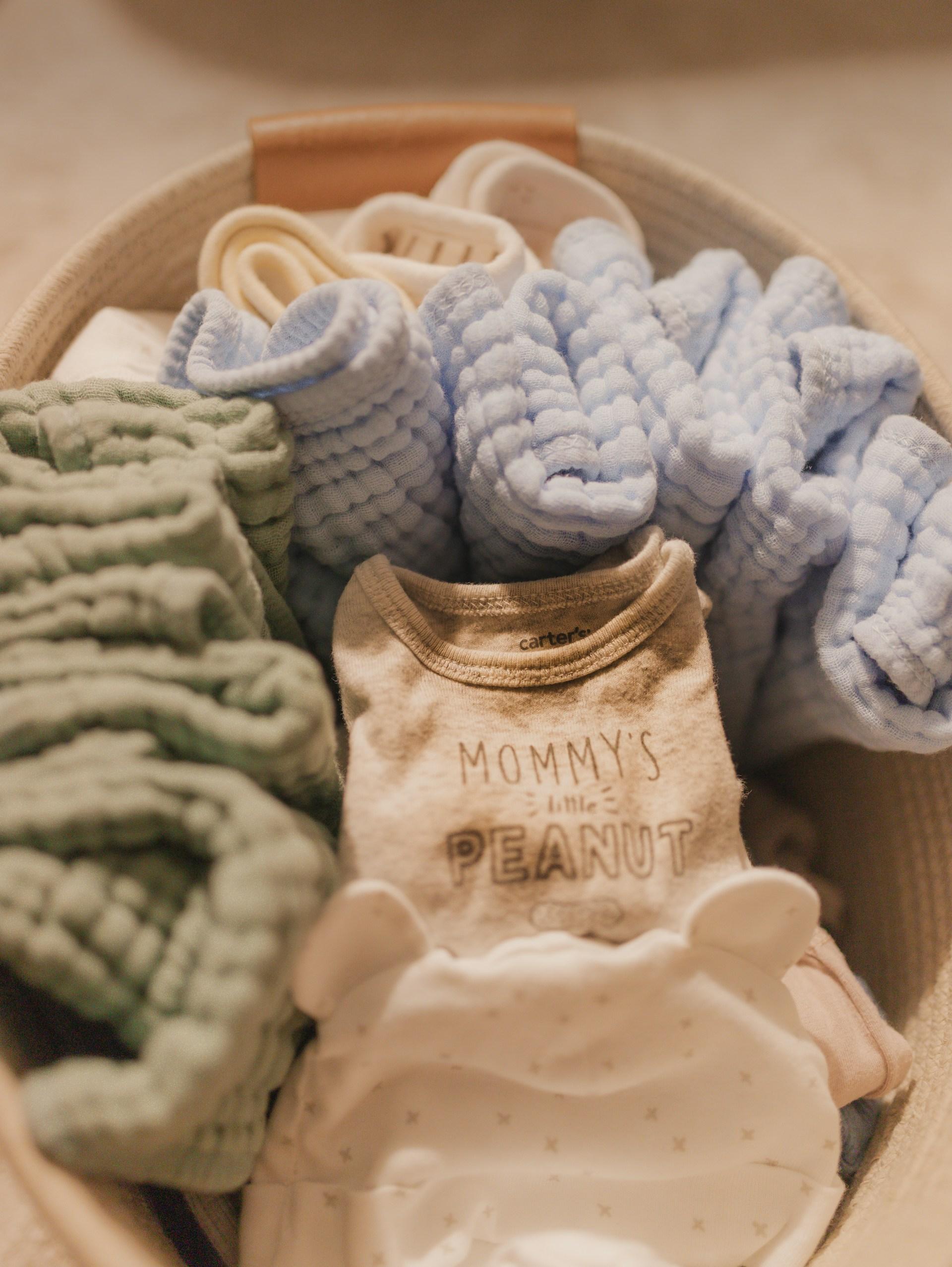 Minimal newborn essentials laid out on a bed