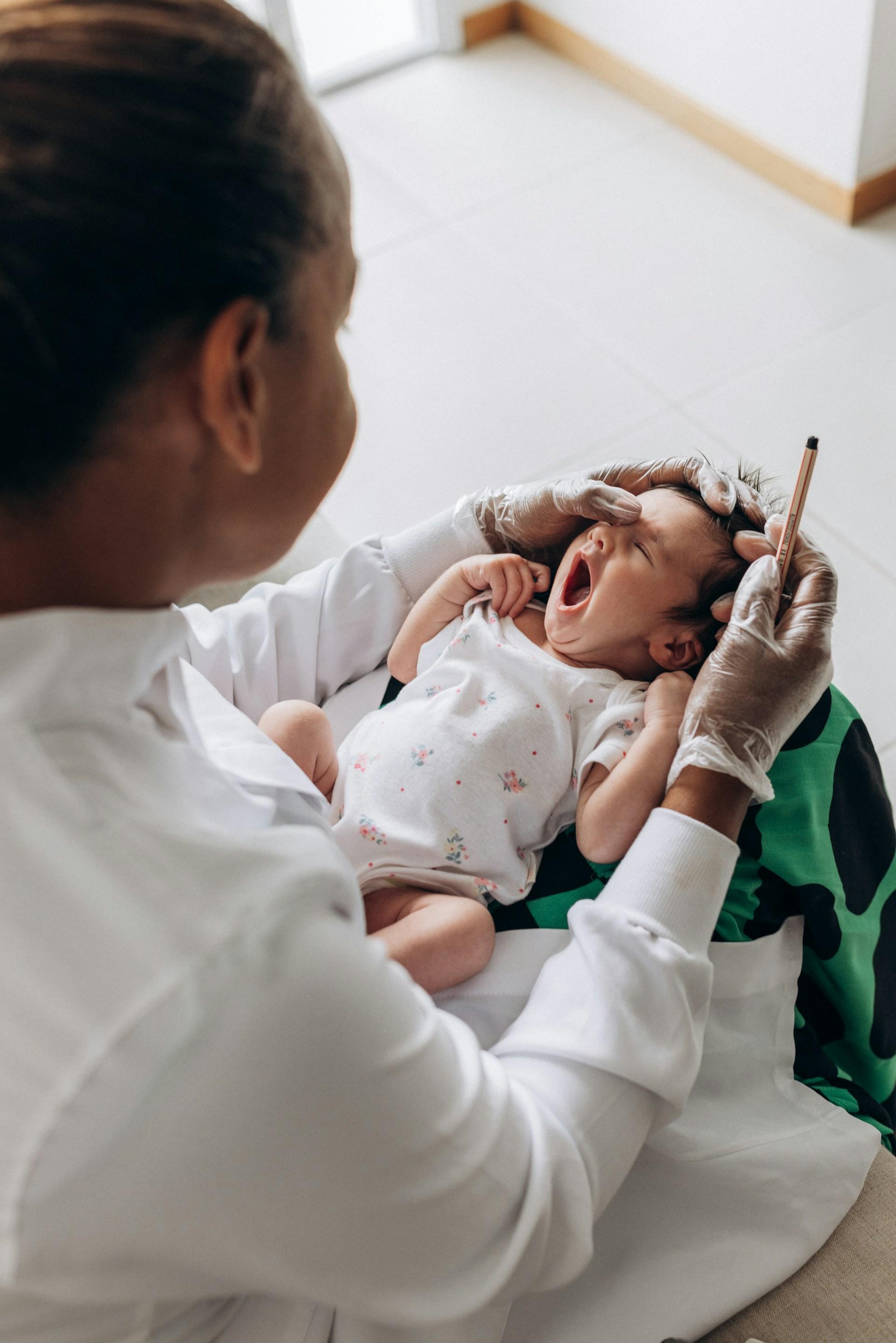 Pediatra examinando a un recién nacido en consulta