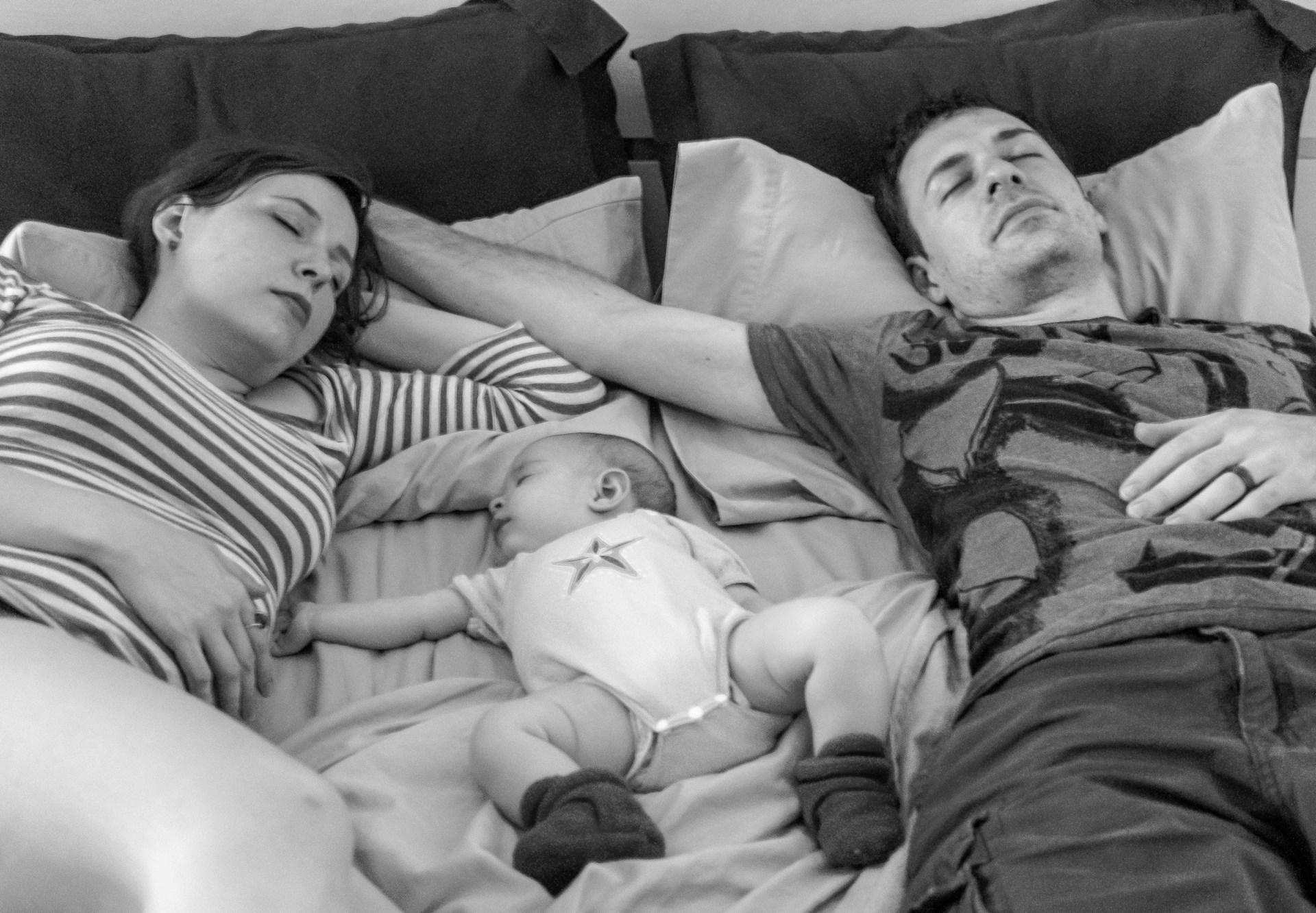 Parent allongé avec bébé en cododo, chambre sécurisée