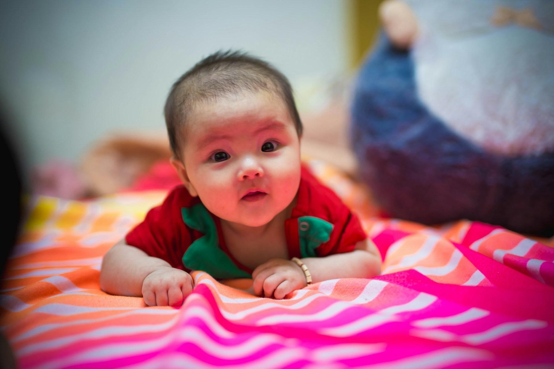 Ibu memegang bayi 3 minggu semasa tummy time
