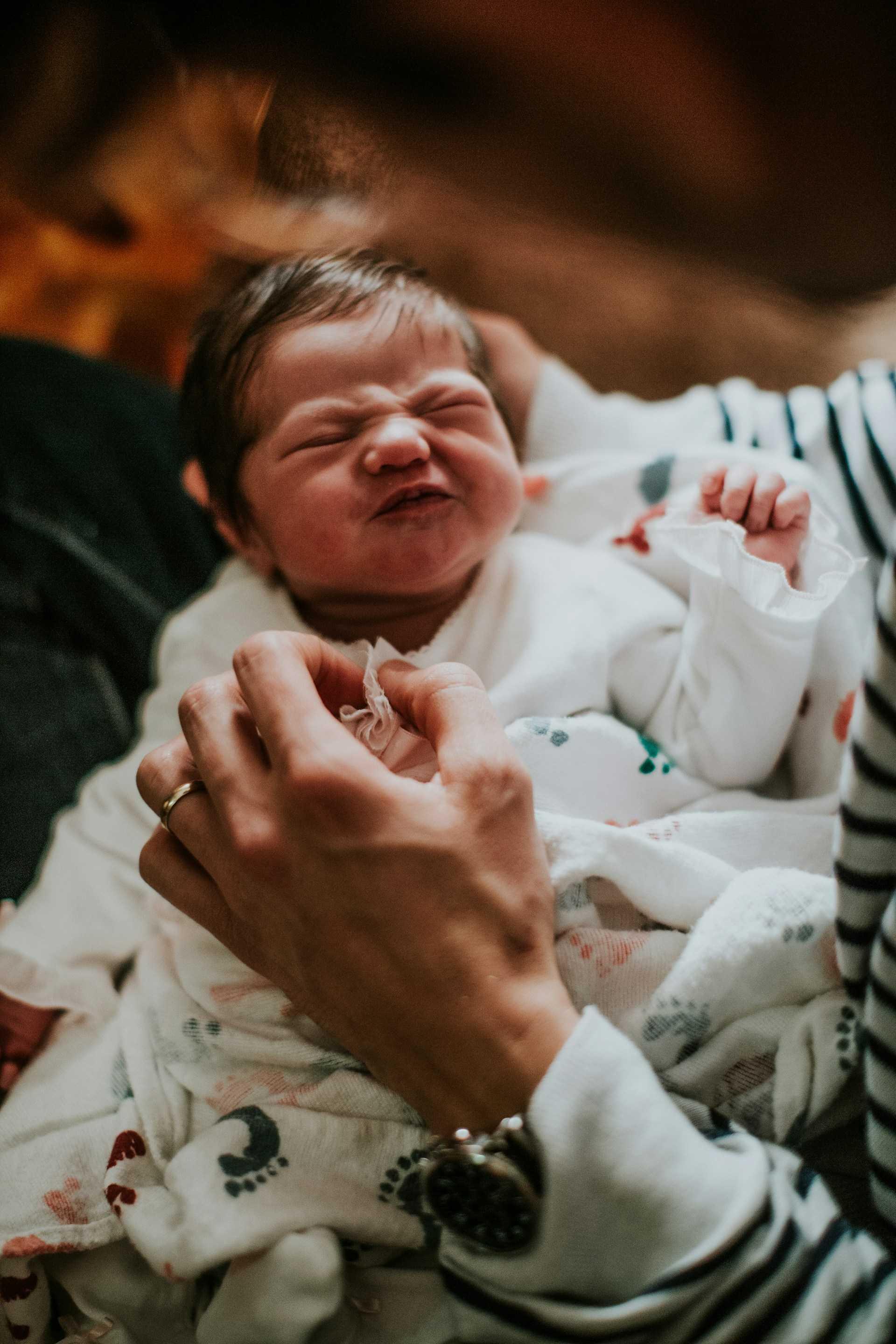 Forelder som renser babyens øyne og nese