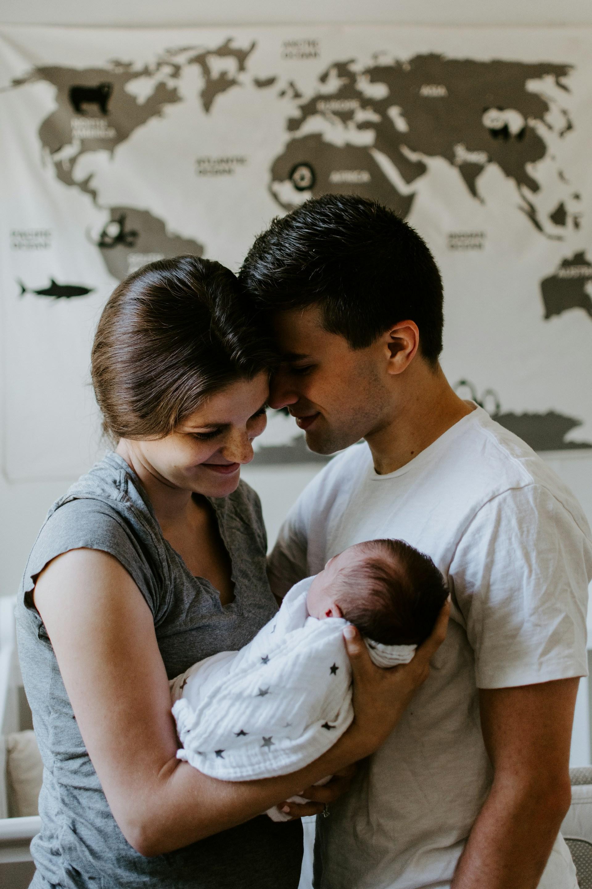 Dad holding newborn skin-to-skin while partner rests