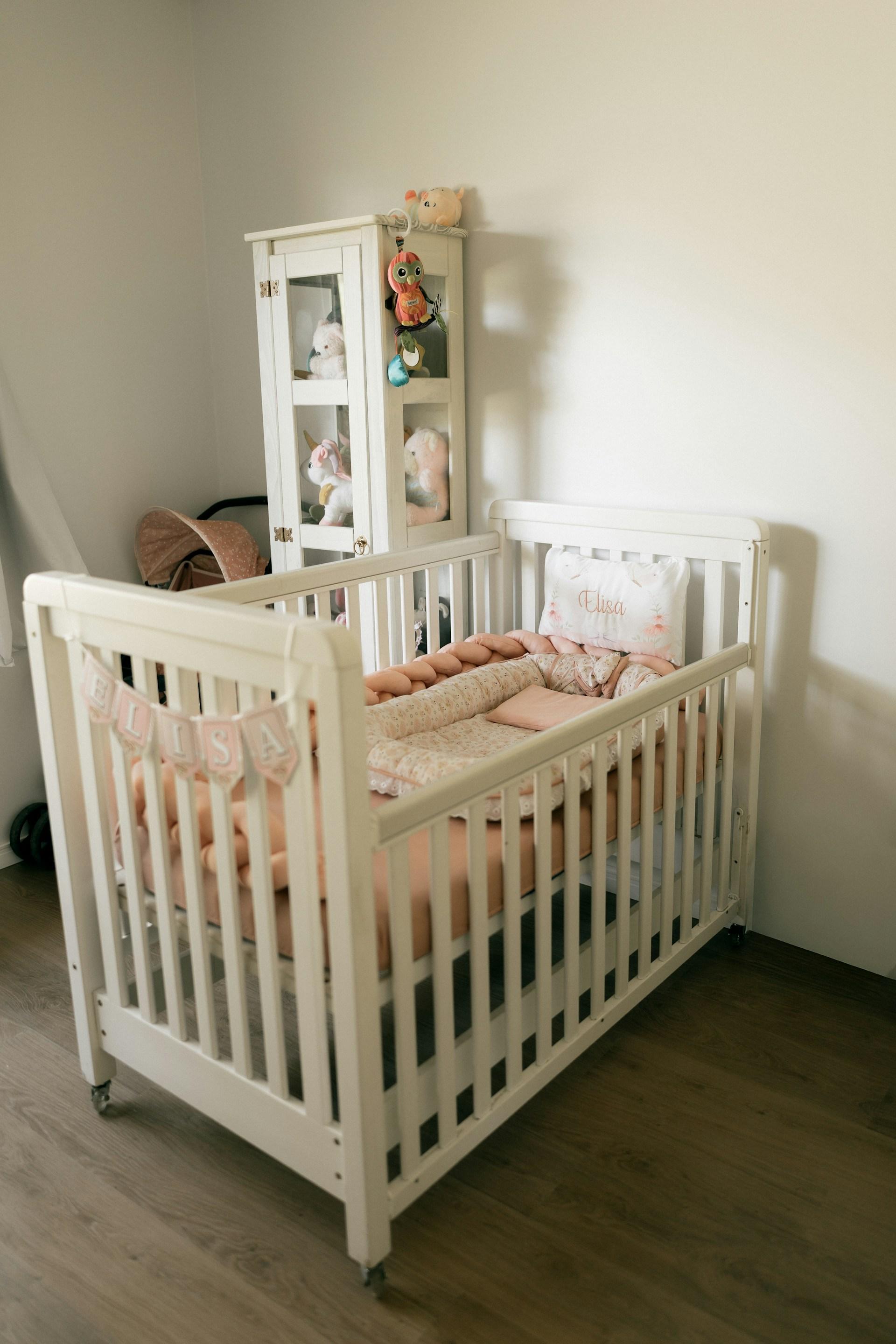 Parent checking crib slats and mattress in nursery