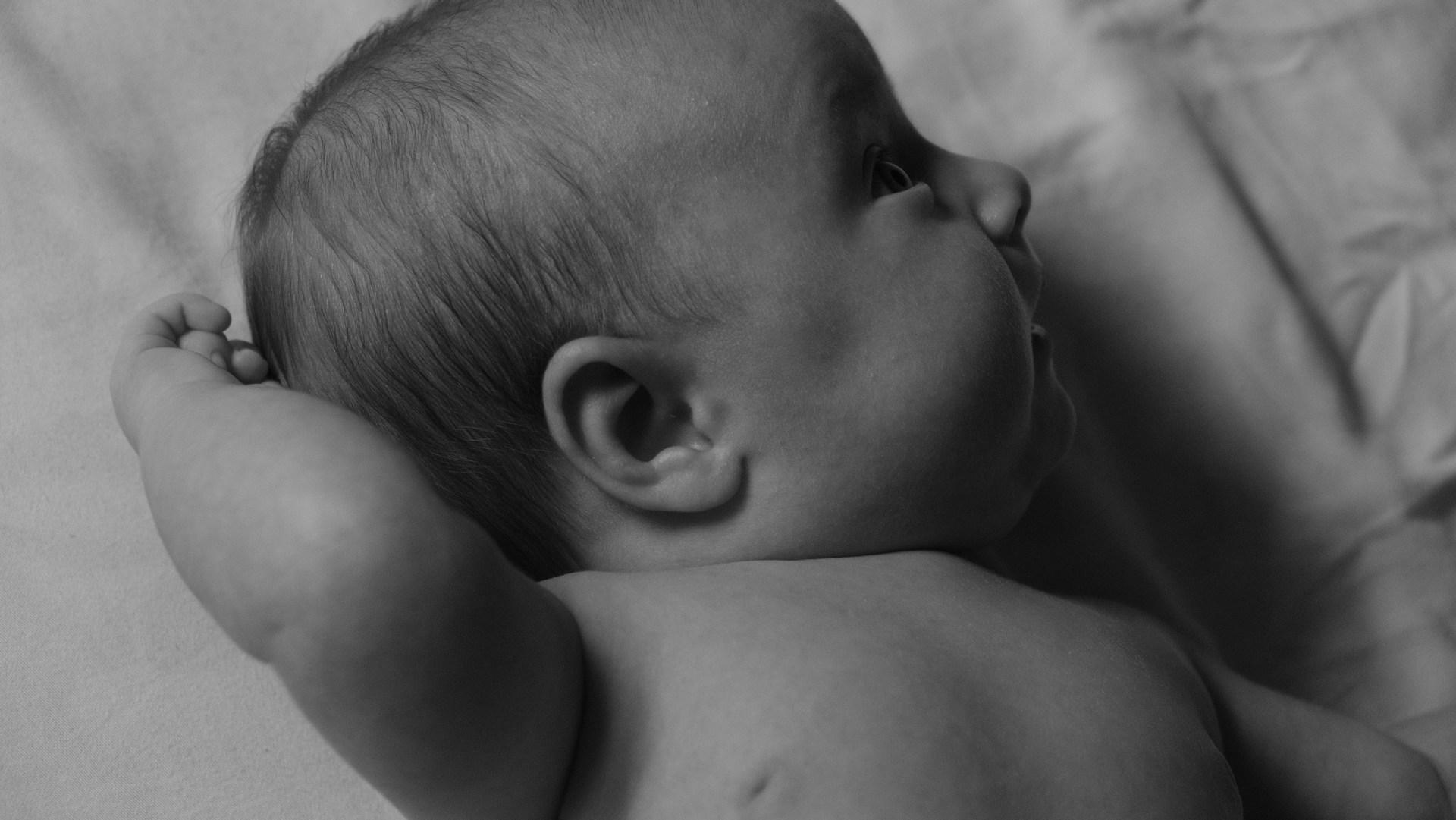 3-nädalane beebi kõhuli, õrnalt pead tõstes